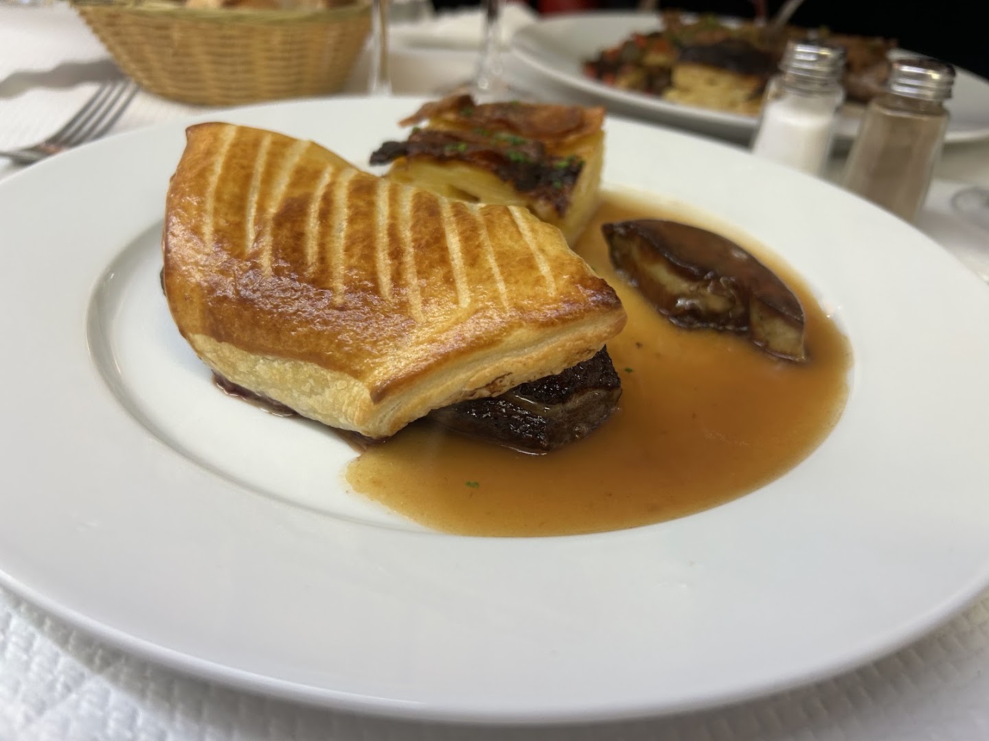 Feuilleté et accompagnements servis dans une assiette blanche