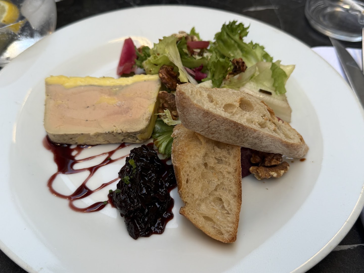 Terrine, salade et pain dans une assiette blanche